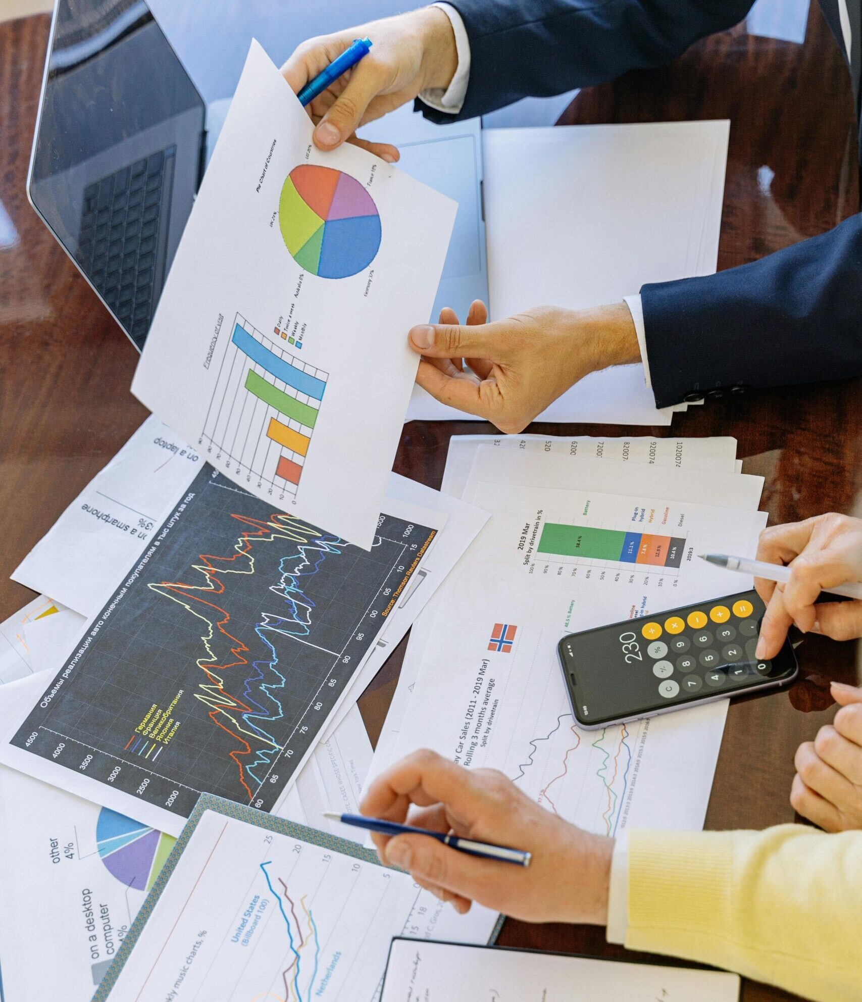 Business professionals analyzing financial charts and graphs during a meeting.